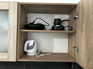 a wooden cabinet with a microwave and appliances in it at Sunflower suite Trikala in Tríkala