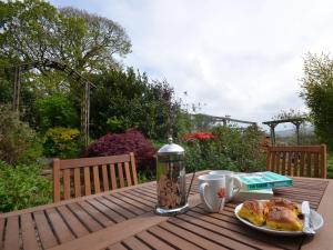 a table with a plate of food and a cup of coffee at 2 Bed in Tintagel 51184 in Lanteglos