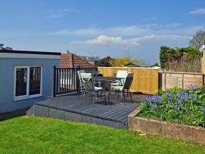 a patio with a table and chairs on a deck at 3 Bed in Brixham BX002 in Brixham
