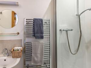ein Bad mit einer Dusche, einem Waschbecken und einem Spiegel in der Unterkunft 4 Bed in Nr Ludlow CHL22 in Aymestrey