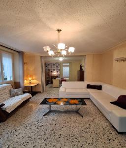 a living room with a white couch and a table at Gîte Le Cep de Bouzy in Bouzy