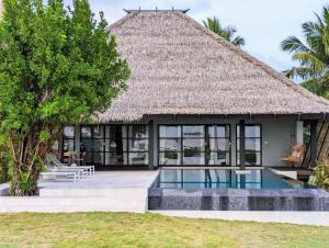 a villa with a swimming pool and a thatched roof at Kalinaw Resort in General Luna