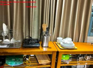 a wooden table with plates and utensils on it at Nice room located right next to the Old Quarter Căn phòng nhiều ánh sáng tại ngay gần phố đi bộ Hồ Gươm in Hanoi