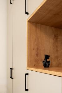 a kitchen cabinet with a black vase sitting on a shelf at Urban Studios near Iulius Mall in Cluj-Napoca