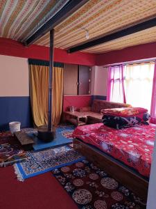 a bedroom with a bed and a couch at Nawang HomeStay in Kaza