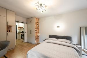 a bedroom with a large bed and a kitchen at Urban Studios near Iulius Mall in Cluj-Napoca