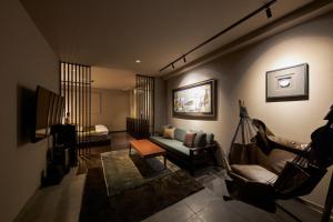 a living room with a couch and a chair at SAKE Kura Hotel 川崎宿 in Kawasaki