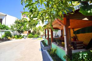 Pemaj Hostel في شكودر: مبنى فيه شجرة بجانب شارع