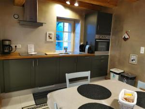 a kitchen with green cabinets and a table and a window at Gite Clos Angélique in Hazelbourg