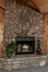 einen Steinkamin in einem Haus mit einer Steinmauer in der Unterkunft 2403 - Oak Knoll #4 cabin in Big Bear Lake