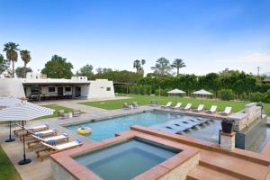 una piscina con tumbonas y un complejo en Starlight Estate by AvantStay 26 People Architectual Mansion w Pool Tennis Court Game Room, en Bermuda Dunes