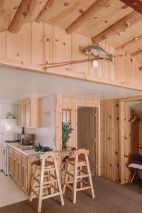 a kitchen with wooden cabinets and a table with stools at 2404 - Oak Knoll Studio #5 cabin in Big Bear Lake
