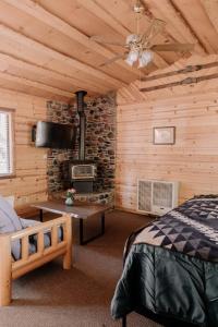 1 dormitorio con 1 cama y chimenea de piedra en 2408 - Oak Knoll ADA Studio #10 cabin, en Big Bear Lake
