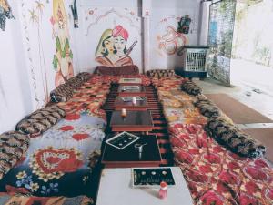 a row of tables in a room with a painting on the wall at Hotel Old Moon Cafe in Pushkar