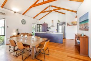a kitchen and dining room with a wooden table and chairs at Footsteps By The Bay in Dunsborough