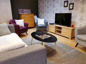 - un salon avec un canapé et une télévision dans l'établissement Gite Clos Angélique, à Hazelbourg