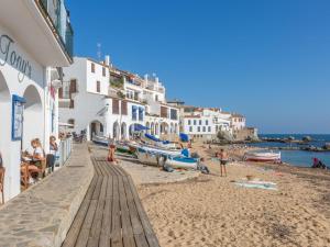 a beach with white buildings and people on the sand at 0328 Apartment in Calella de Palafrugell in Calella de Palafrugell