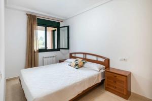 1 dormitorio con 1 cama, mesita de noche y ventana en Apartamento Llanes Paraiso 206, en Posada de Llanes