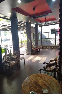 瓜埠的住宿－Bull & Bear Airport Hotel Langkawi，一间带桌椅的餐厅以及一间设有窗户的房间