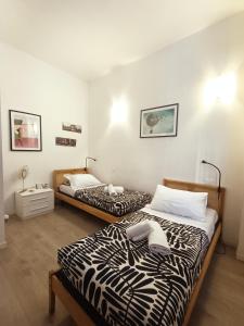 フィレンツェにあるMeri Apartmentのベッド2台が備わる客室で、