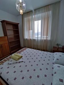 een slaapkamer met een groot bed met een raam en een bed van zes bij Xata 1+2 in Alma-Ata