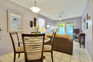 a dining room and living room with a table and chairs at Lavender Jungle by AvantStay Great Location w Patio Shared Pool Week Long Stays Only in Key West