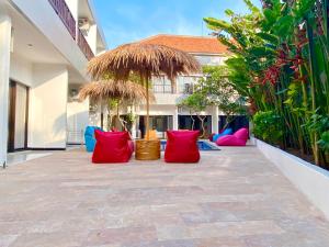 a courtyard with red and blue pillows in front of a building at Hotel Summer Of Surf in Ungasan