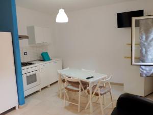 a small kitchen with a white table and chairs at Calliope in Marsala
