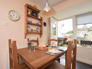 a dining room table with chairs and a clock on the wall at 1 bed in Brixham BX046 in Brixham