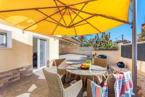 - une table avec un parasol jaune sur la terrasse dans l'établissement Villa Campanilla - Plusholidays, à Calp