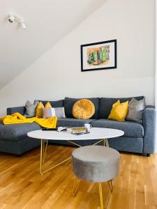 uma sala de estar com um sofá azul e uma mesa em APSTAY Serviced Apartments - Self Check-in em Graz