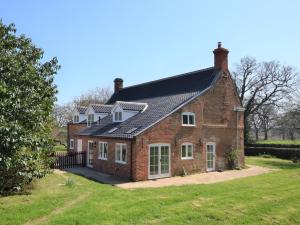 a red brick house with a black roof at 5 Bed in Wroxham 56103 in Hoveton