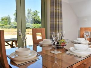 a dining room table with plates and wine glasses at 2 Bed in Croes-y-pant 58961 in Mamhilad