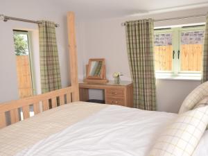 a bedroom with a bed and a mirror and windows at 2 Bed in Croes-y-pant 58961 in Mamhilad