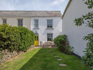 a white house with a yellow door and a yard at 4 bed property in Instow Devon 59699 in Instow