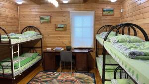 a room with three bunk beds and a desk at Hostel SHYMBULAK in Almaty