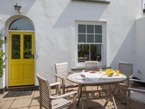 a yellow door on a patio with a table and chairs at 4 bed property in Instow Devon 59699 in Instow