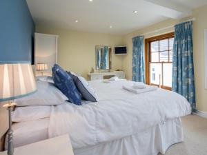 a bedroom with a large white bed with blue pillows at 4 bed property in Instow Devon 59699 in Instow