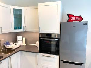 a kitchen with white cabinets and a stainless steel refrigerator at Ferienwohnungen Arp "Garage" mit Parkplatz in Itzehoe