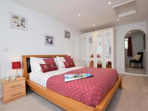 um quarto com uma cama grande com lençóis vermelhos e brancos em 1 Bed in Lyme Regis 62615 em Axminster