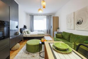a living room with a green couch and a table at New Green Studio Apartment near Tvrđa in Osijek