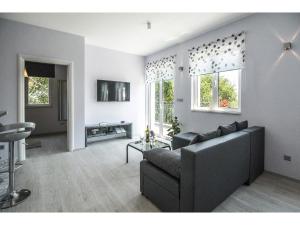 un salon avec un canapé et deux fenêtres dans l'établissement Apartment Splendid Marjan, à Split