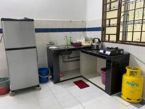 uma pequena cozinha com um lavatório e um frigorífico em Go Holiday Taiping Homestay em Simpang