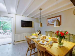 a dining room with a wooden table with flowers on it at 3 Bed in Cartmel 66725 in Holker