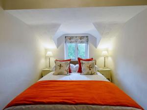 Holker的住宿－3 Bed in Cartmel 66725，一间卧室配有一张带橙色毯子的床