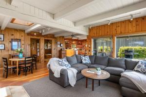 un soggiorno con divano e tavolo di The Pilot House by AvantStay Stunning Home Right On Arch Cape Beach ad Arch Cape