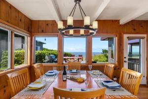 una sala da pranzo con tavolo, sedie e finestre di The Pilot House by AvantStay Stunning Home Right On Arch Cape Beach ad Arch Cape