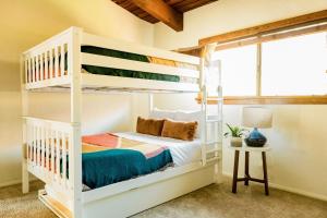 a white bunk bed in a room with a table at Cliffridge by AvantStay Lush Malibu Hills Estate w Breathtaking Ocean Views in Malibu