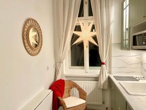 cocina con ventana, silla y reloj en Nest Apartment en Sopot