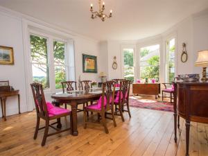 a dining room with a table and pink chairs at 4 Bed in Lulworth Cove DC182 in West Lulworth